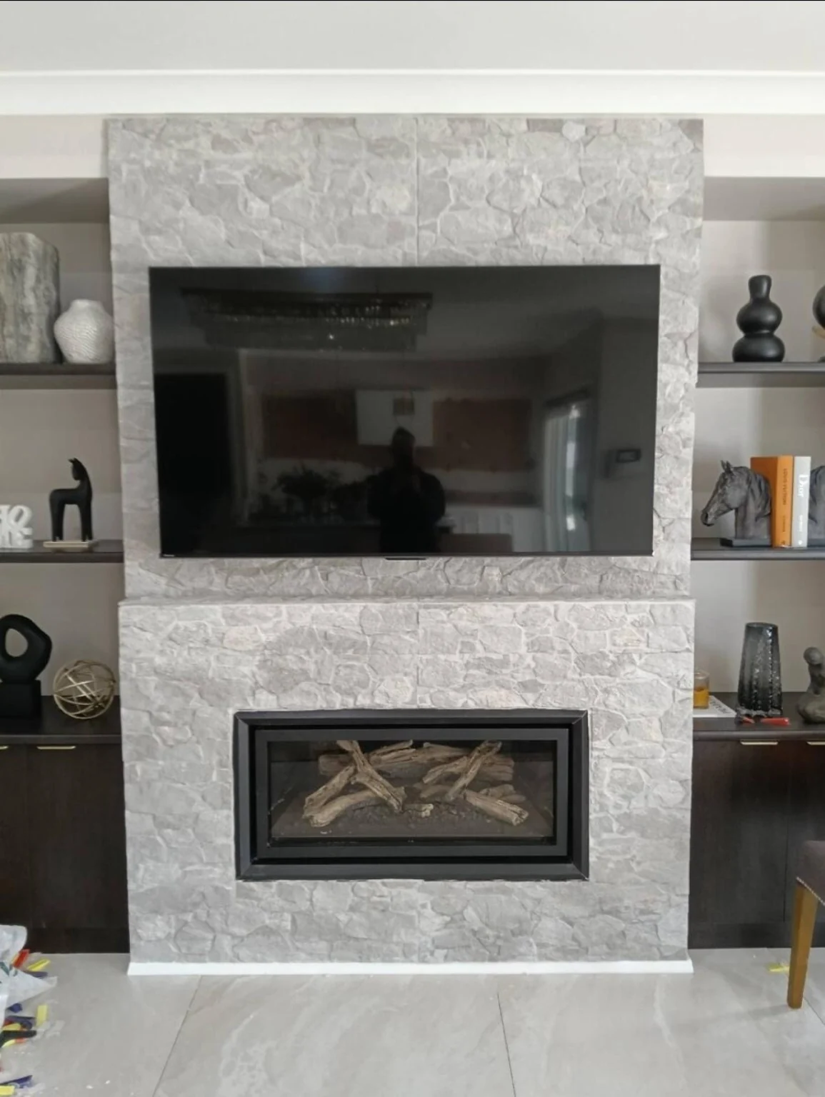 Television mounted on a stone-faced feature wall.