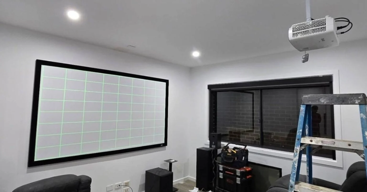 Projector, screen and AV equipment during room setup.