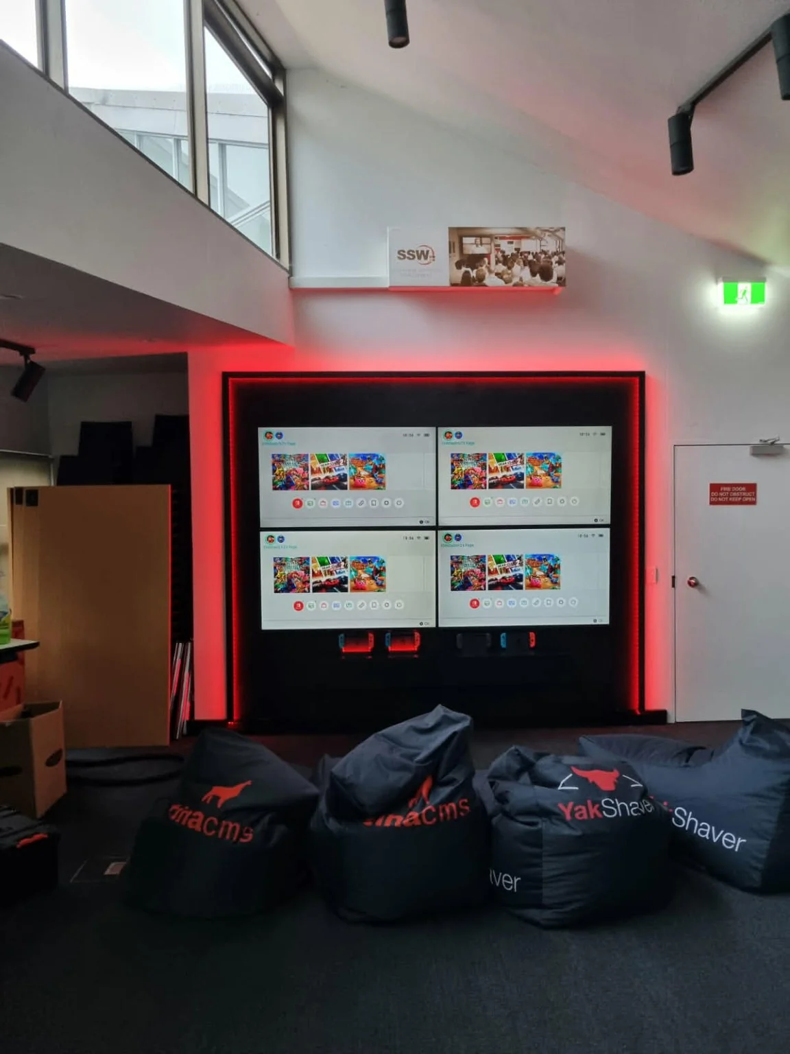 A red-lit multi-screen feature in a gaming lounge.